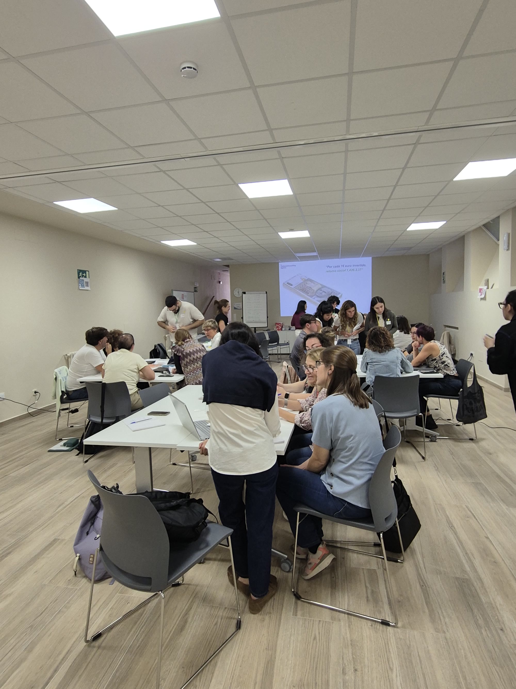 Equipo participante en una formacion de SROI trabajando en grupo en una sala